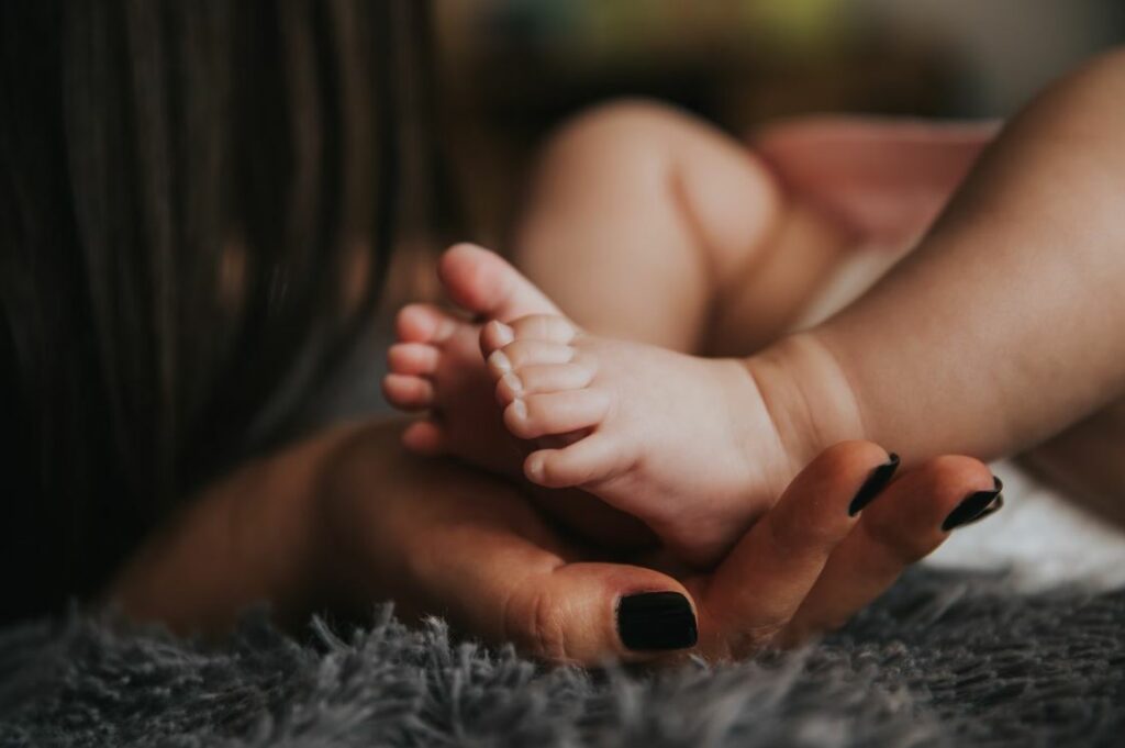 maman en baisse de libido tenant les pieds de son bébé